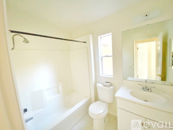 A white bathroom with a toilet, sink, and bathtub.