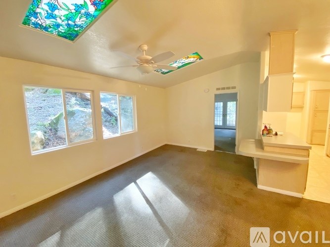 A room with a stained glass window and a ceiling fan.