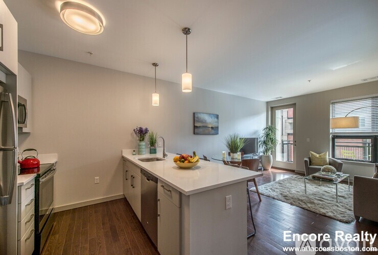 A kitchen with white cabinets and a refrigerator.