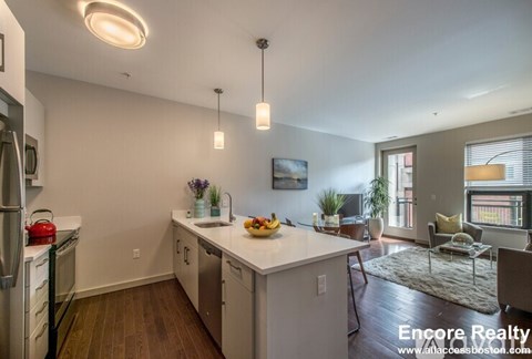 A kitchen with white cabinets and a refrigerator.