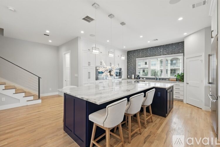 A modern kitchen with a large island and bar stools.