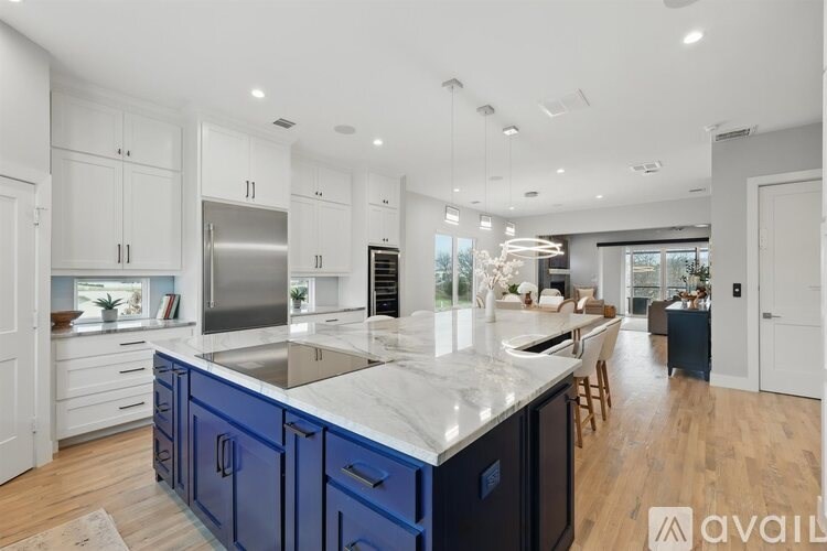 A modern kitchen with blue cabinets and a marble countertop.