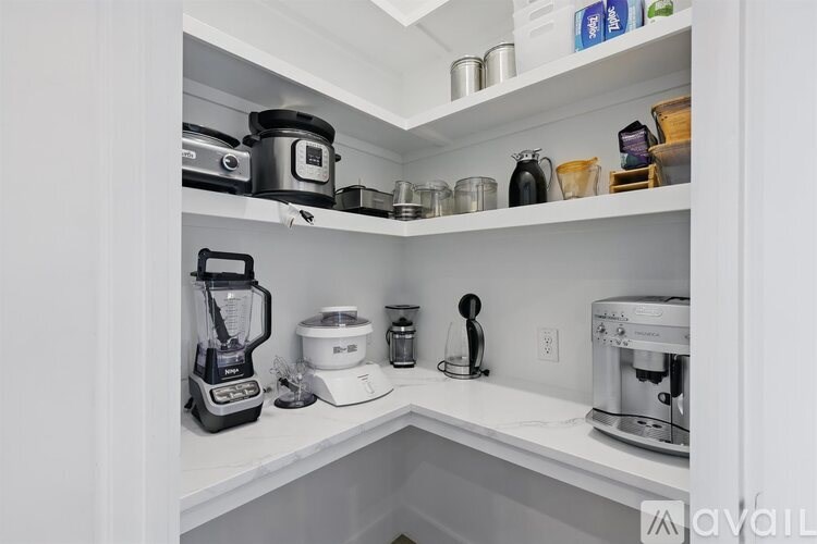 A kitchen with a white counter and a coffee maker on it.