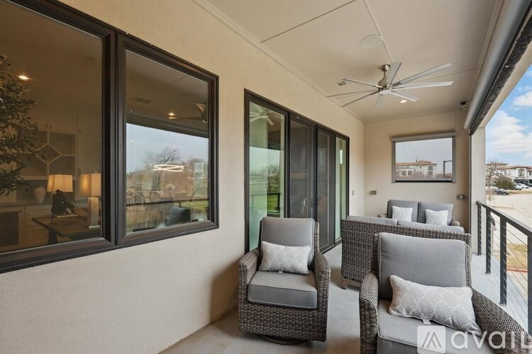 Two grey chairs are placed on a balcony.