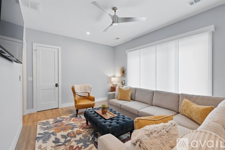A living room with a couch, chair, and rug.