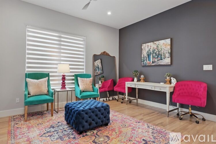 A room with a grey wall and a painting hanging on it.