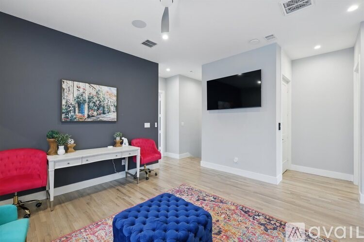 A room with a grey wall and a painting on it.