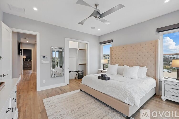 A bedroom with a large bed, a dresser, and a mirror.