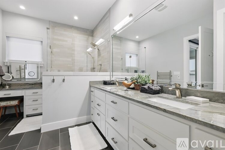 A bathroom with a marble countertop and a large mirror.
