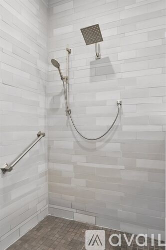 A bathroom with a shower and a tiled wall.