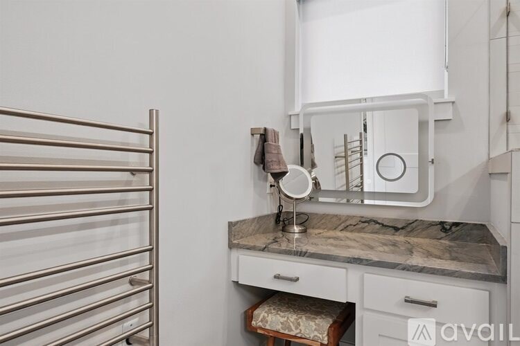 A bathroom vanity with a marble countertop and a mirror above it.