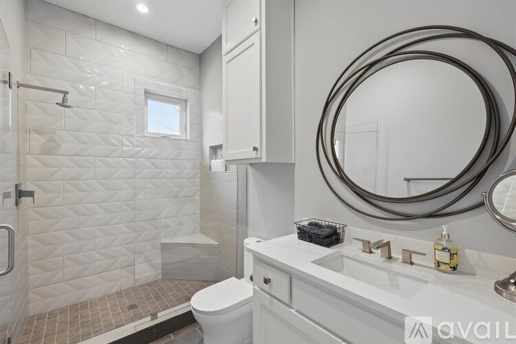 A bathroom with a white toilet, a white sink, and a white shower.