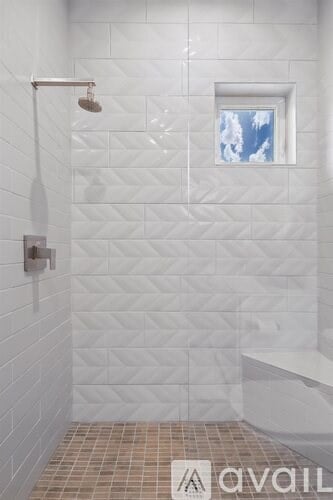 A bathroom with a shower and a window.