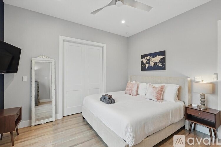 A bedroom with a large bed, a television, and a wooden table.