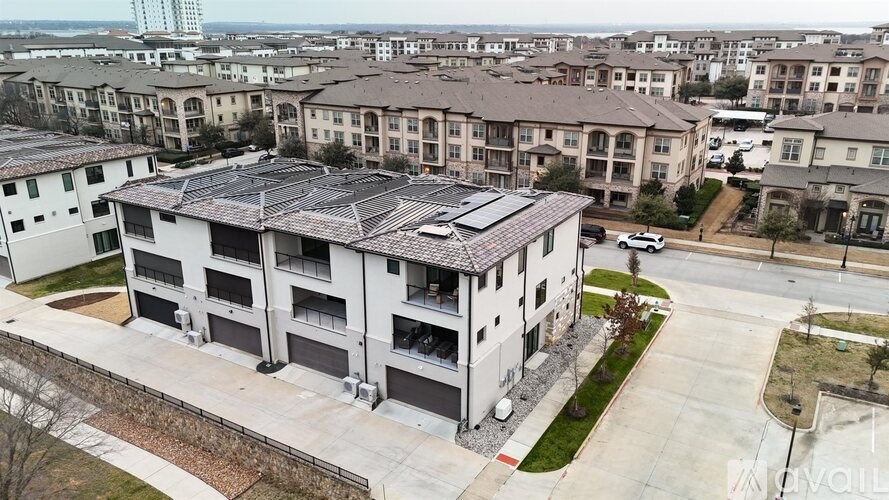 A large apartment complex with a parking lot in front.