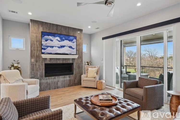 A living room with a large TV mounted on the wall above a fireplace.