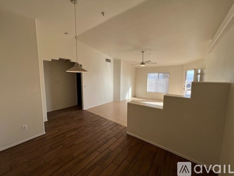 A spacious room with wooden floors and a large window.