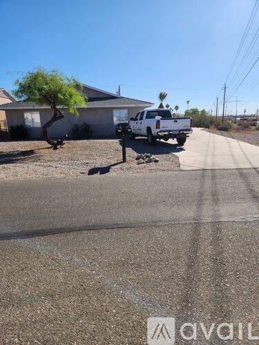 A white pickup truck is parked on the side of a road.