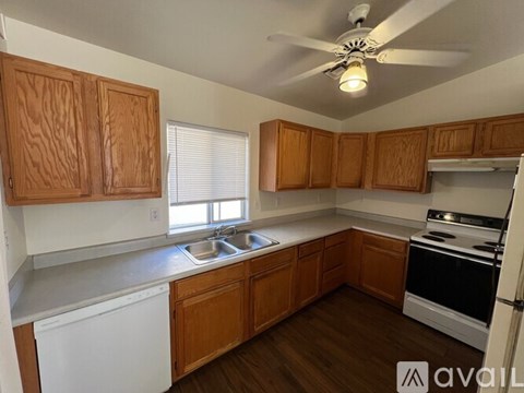 A kitchen with wooden cabinets and a white dishwasher.