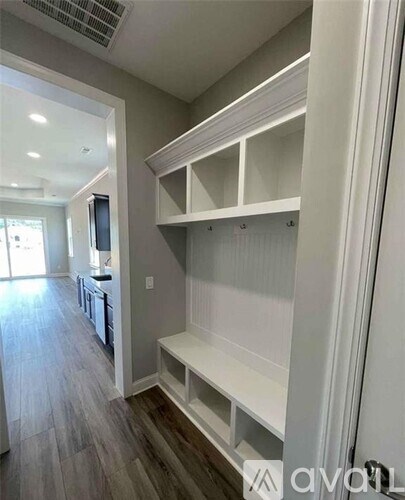 A kitchen with a white cabinet and a TV on the wall.