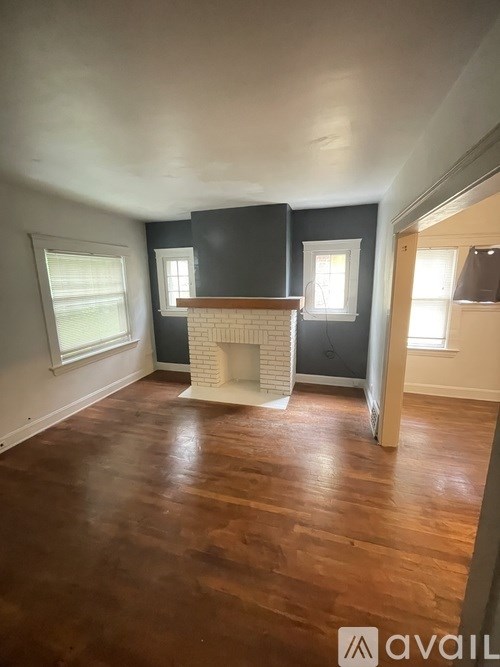 A room with a fireplace and wooden floors.