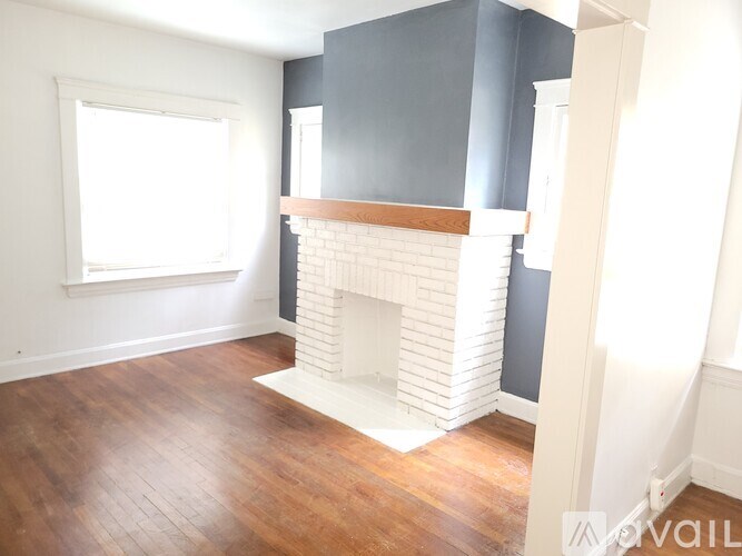 A room with a fireplace and wooden floors.