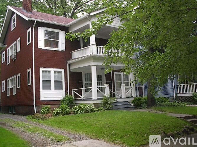 A red brick house with a white porch.