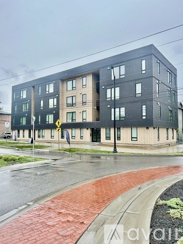 A modern building with a black facade and a yellow warning sign on the side.