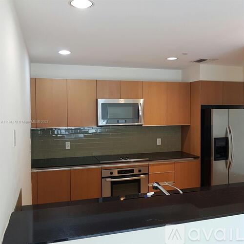 A kitchen with wooden cabinets and a black countertop.