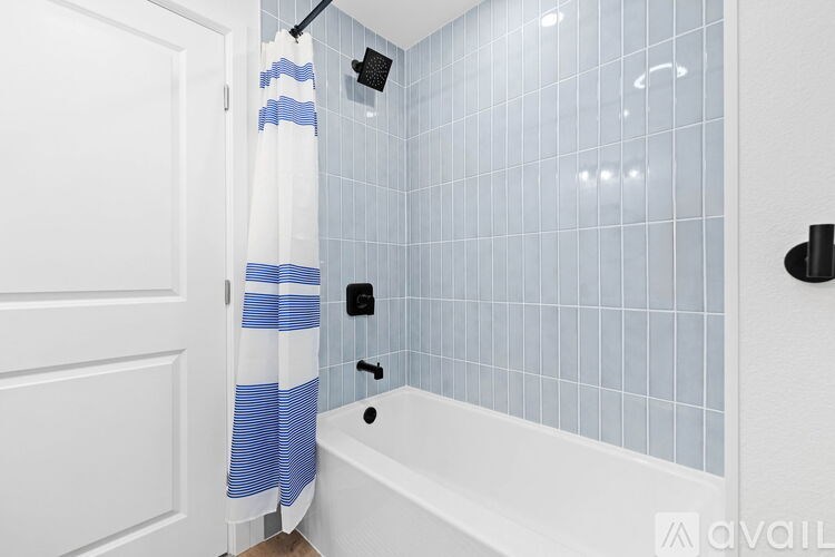 A white bathroom with a blue and white shower curtain.