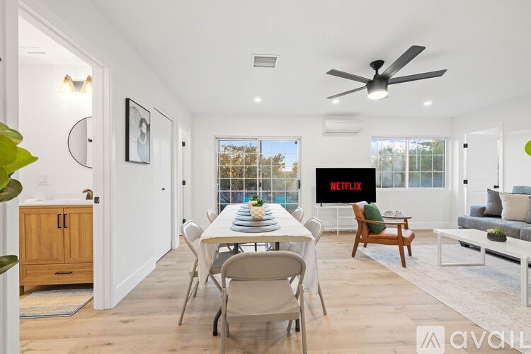 A living room with a dining table set up in front of a TV displaying the Netflix logo.
