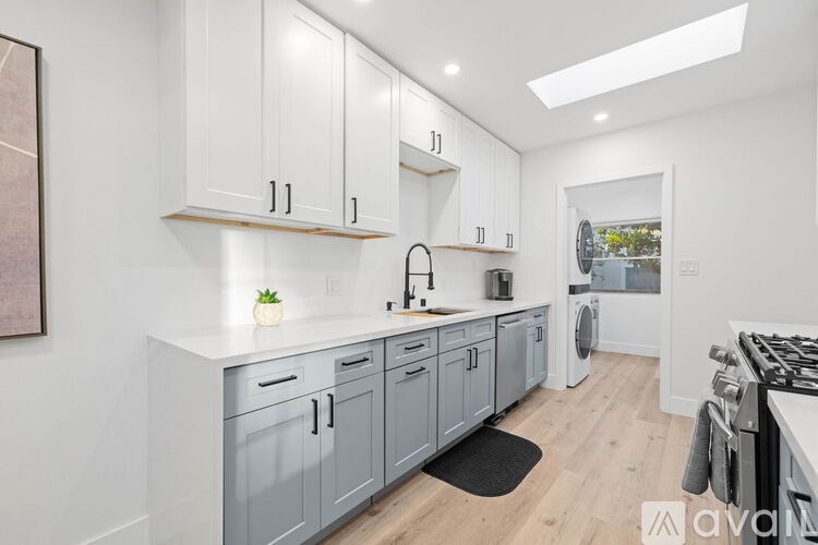 A modern kitchen with white cabinets and a wooden countertop.