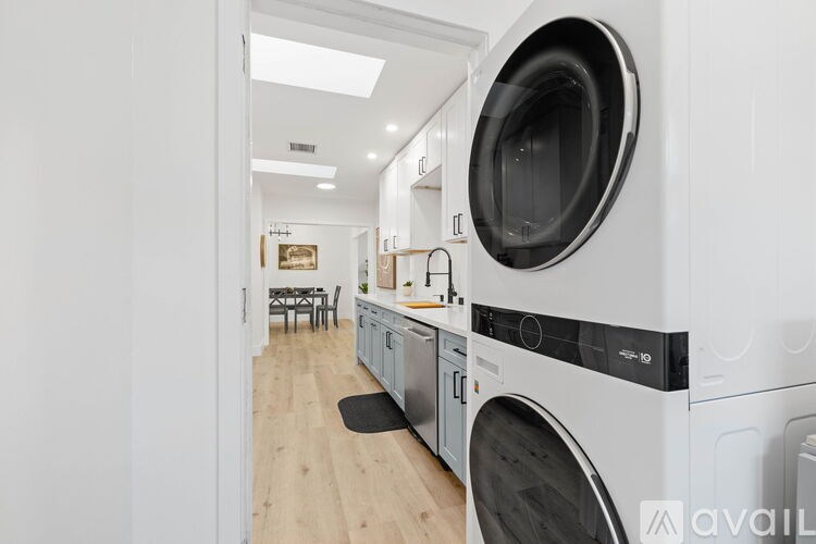A modern kitchen with a washing machine and dryer built into the cabinetry.
