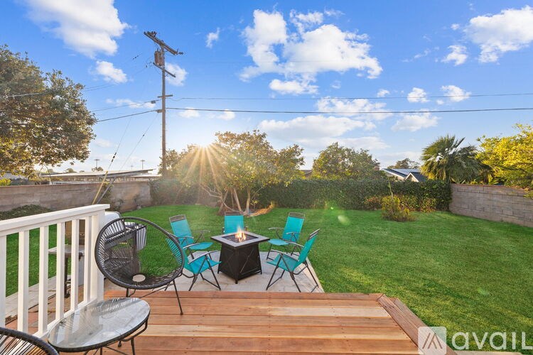 A backyard with a table and chairs set up on a deck.