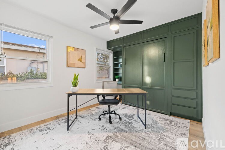 A room with a table, chairs, and a ceiling fan.
