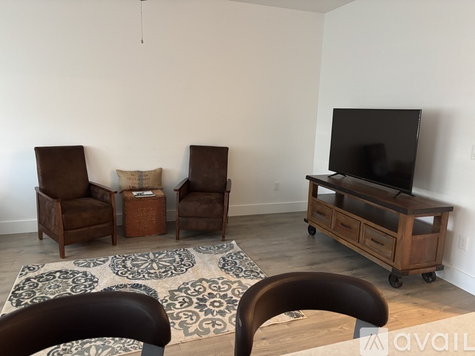 A living room with a television and two chairs.