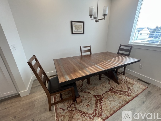 A dining room with a wooden table and chairs.