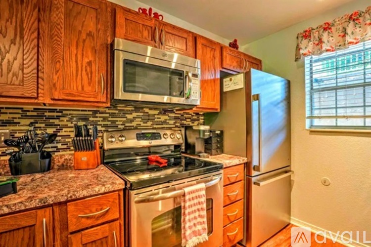 A kitchen with wooden cabinets and a granite countertop.