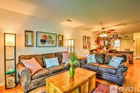 A living room with a brown leather couch and a wooden coffee table.