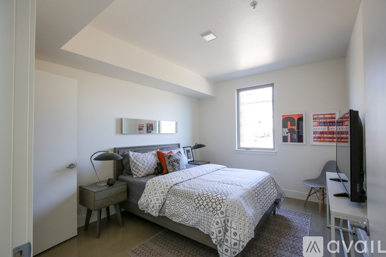 A bedroom with a bed, nightstand, and chair.