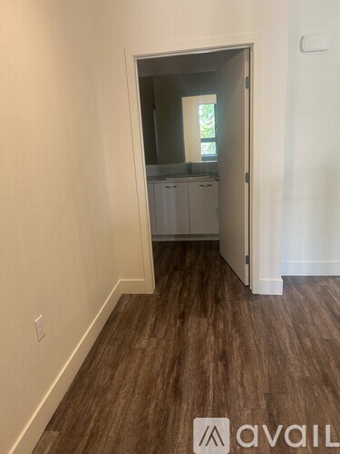 A living room with a black chair and a flat screen TV mounted on the wall.
