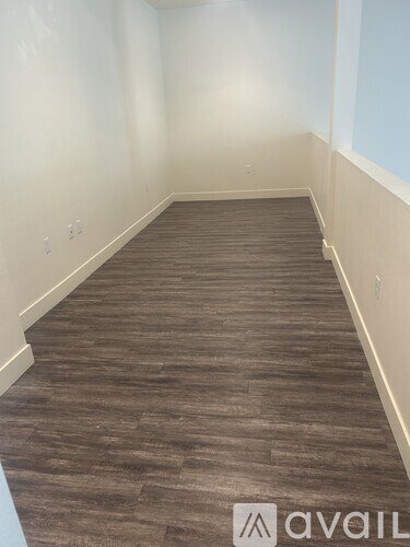 A modern living room with a spiral staircase in the background.