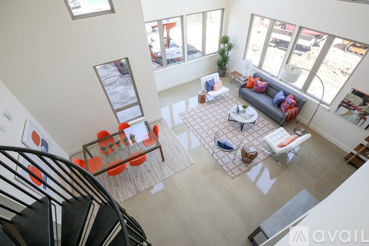 A living room with a couch, a coffee table, and a staircase.