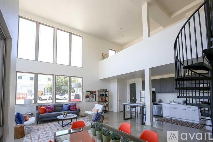 A modern open plan living and dining area with a spiral staircase.