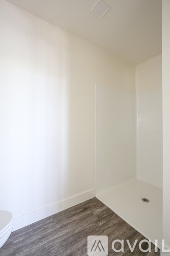 A bathroom with a toilet and a wooden floor.