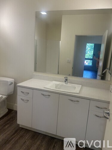 A living room with a staircase on the left and a dining area in the middle.