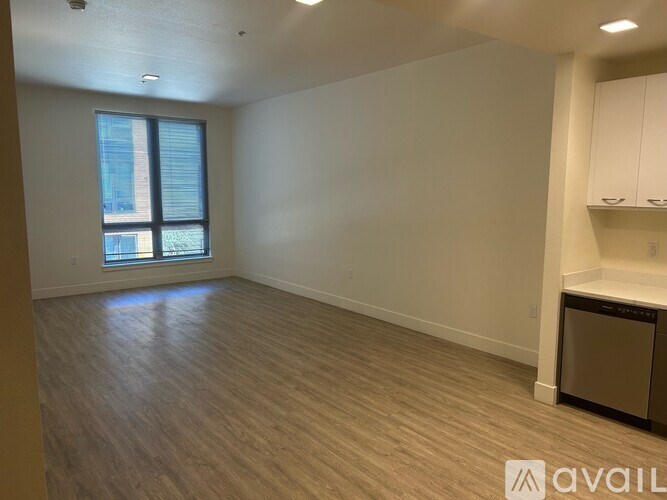 A room with a window and a wooden floor.