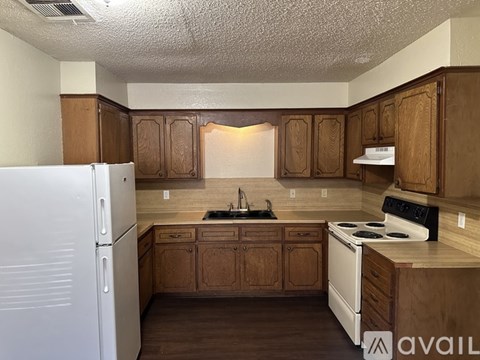A kitchen with wooden cabinets and a white refrigerator.