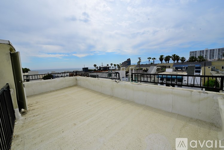 A rooftop with a concrete floor and a metal railing.