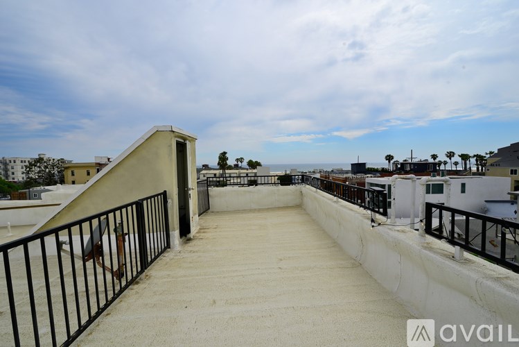 A balcony with a metal railing and a concrete floor.